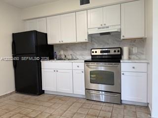 A closet with white louvered doors, interior shelving, and a hanging rod — 50 W 11th St # 1, Hialeah FL 33010, HIALEAH, FL