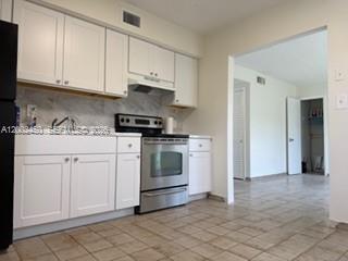 A room with white tiled floors, a ceiling fan, and white bifold closet doors — 50 W 11th St # 1, Hialeah FL 33010, HIALEAH, FL