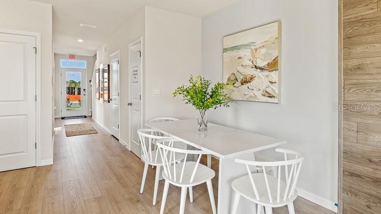A dining area features a white table, four white chairs, and a coastal-themed wall painting — 4029 GOLD DUST LANE, SARASOTA, FL