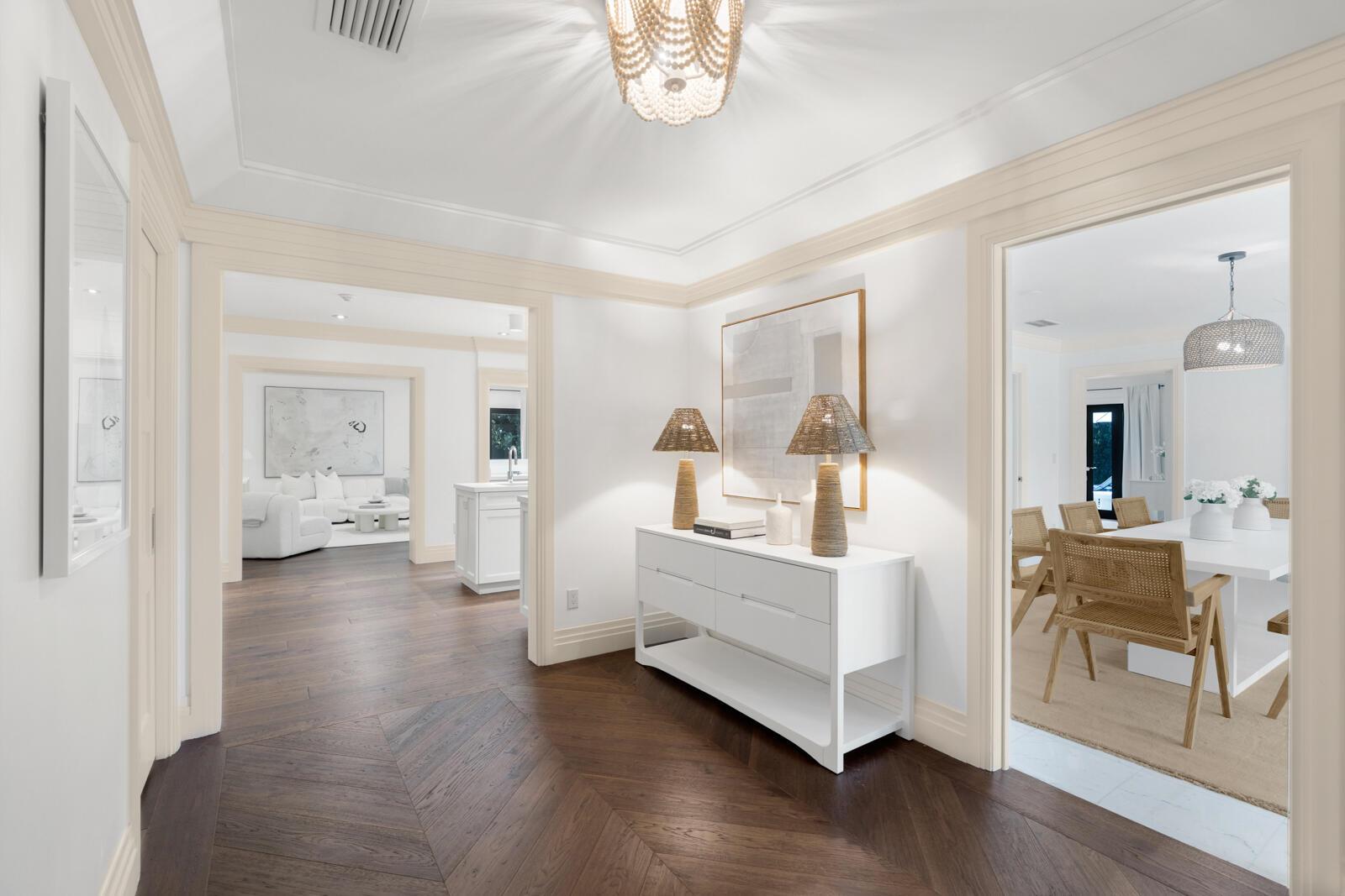 A bright foyer features dark chevron wood floors, a white console table, and arched doorways — 1435 N Ocean Way, Palm Beach FL 33480, PALM BEACH, FL
