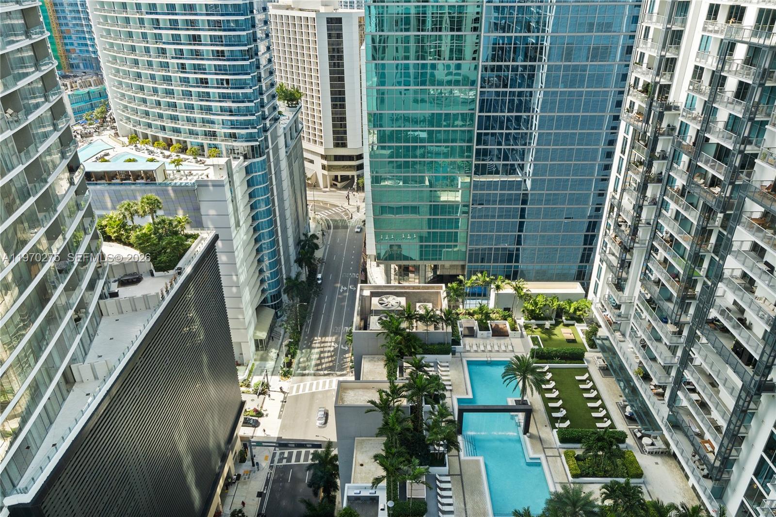 An aerial view shows a city street between high-rise buildings with a rooftop swimming pool — 300 S Biscayne Blvd # 2602, Miami FL 33131, MIAMI, FL