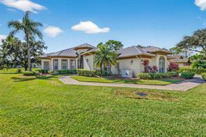 A single-story house with a metal roof, beige stucco walls, and a paved walkway — 3210 Bent Pine Drive, Fort Pierce FL 34951, FORT PIERCE, FL