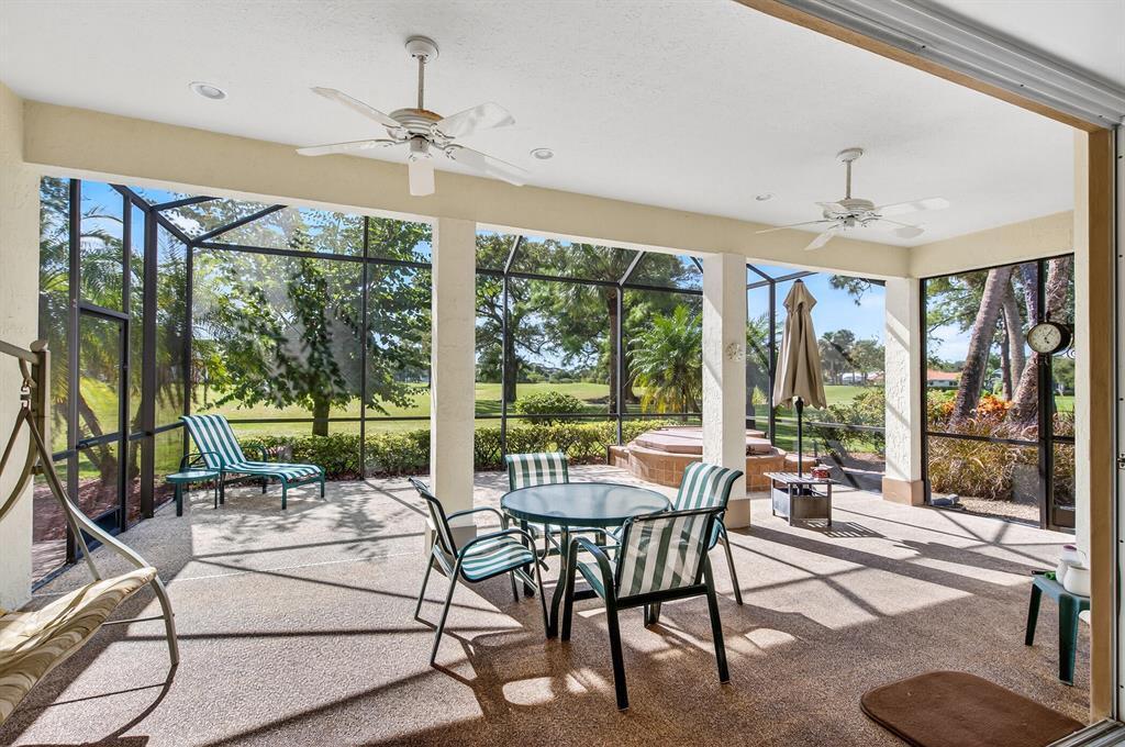 A screened-in patio features a dining set, lounge chair, hot tub, and ceiling fans — 3210 Bent Pine Drive, Fort Pierce FL 34951, FORT PIERCE, FL