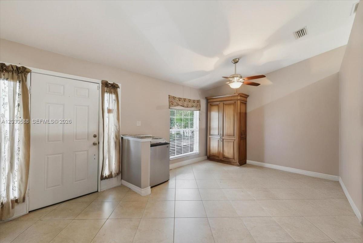 A room with tile flooring, a white door, a window with a valance, and a wooden armoire — 403 SW 28th PL, Cape Coral FL 33991, CAPE CORAL, FL