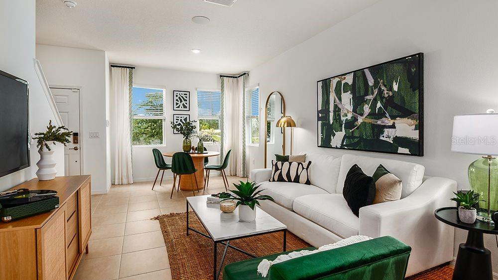 A living room and dining area feature white walls, tile floors, and modern furniture — 10609 ORBIT TERRACE, SARASOTA, FL