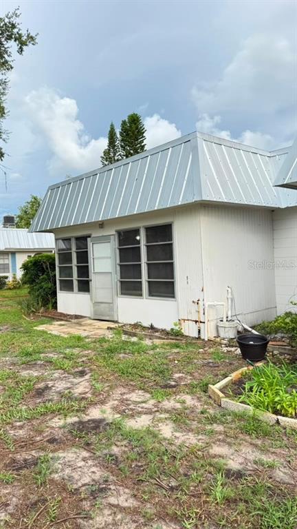 An exterior view of a white building with a metal mansard roof and screen windows — 4248 TAMARGO DRIVE, NEW PORT RICHEY, FL