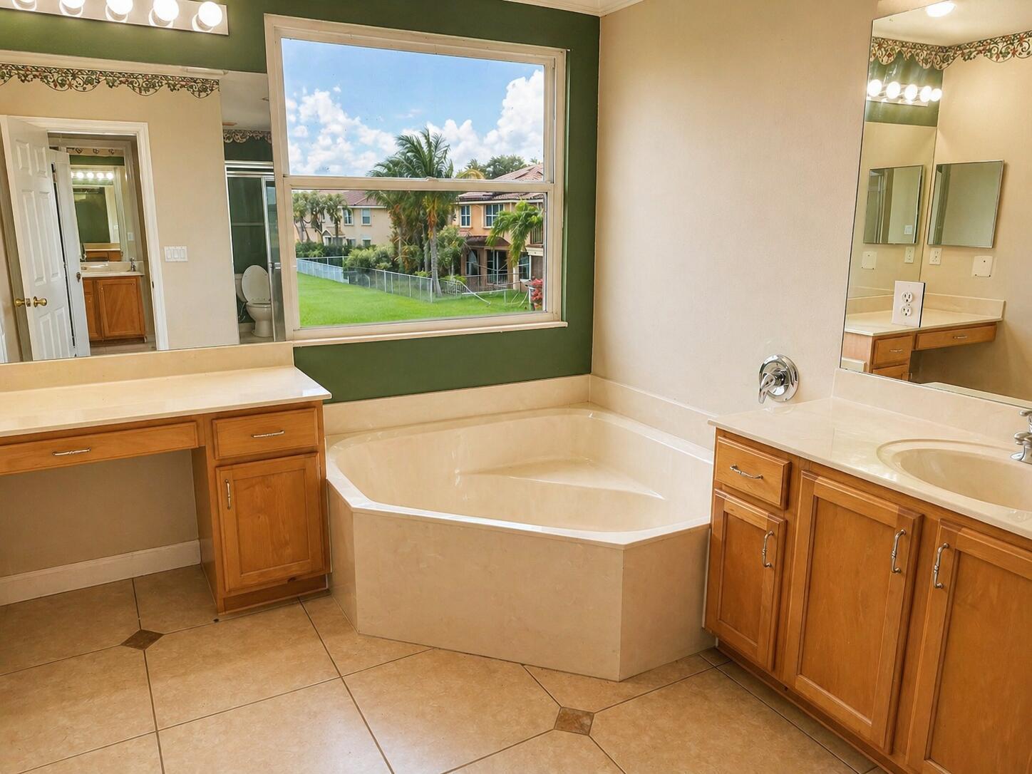 A bathroom features a corner soaking tub, dual wooden vanities, and a large exterior window — 5097 Bright Galaxy Lane, FL 33463, FL