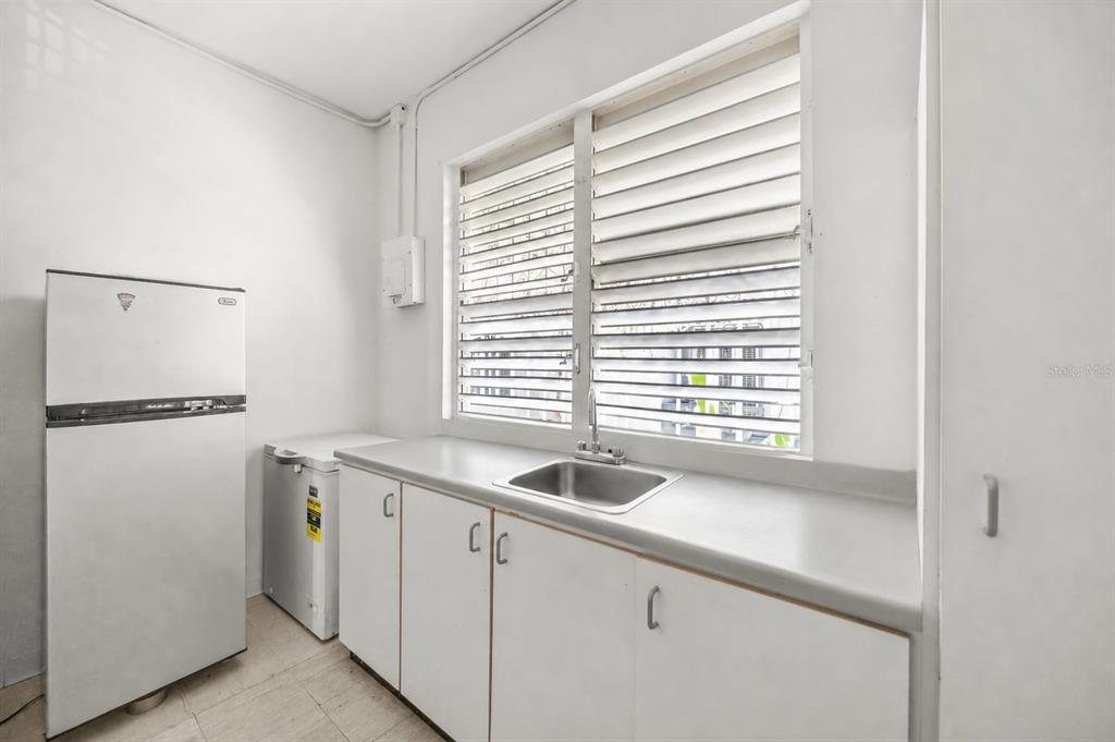 A kitchen features white cabinets, a stainless steel sink, a refrigerator, and a chest freezer — 1410 AMERICO SALAS, SAN JUAN, PR