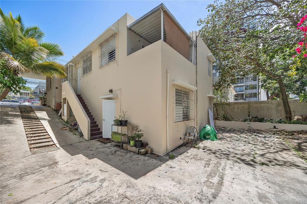 A two-story beige building features an exterior staircase, a covered balcony, and a concrete driveway — 1410 AMERICO SALAS, SAN JUAN, PR