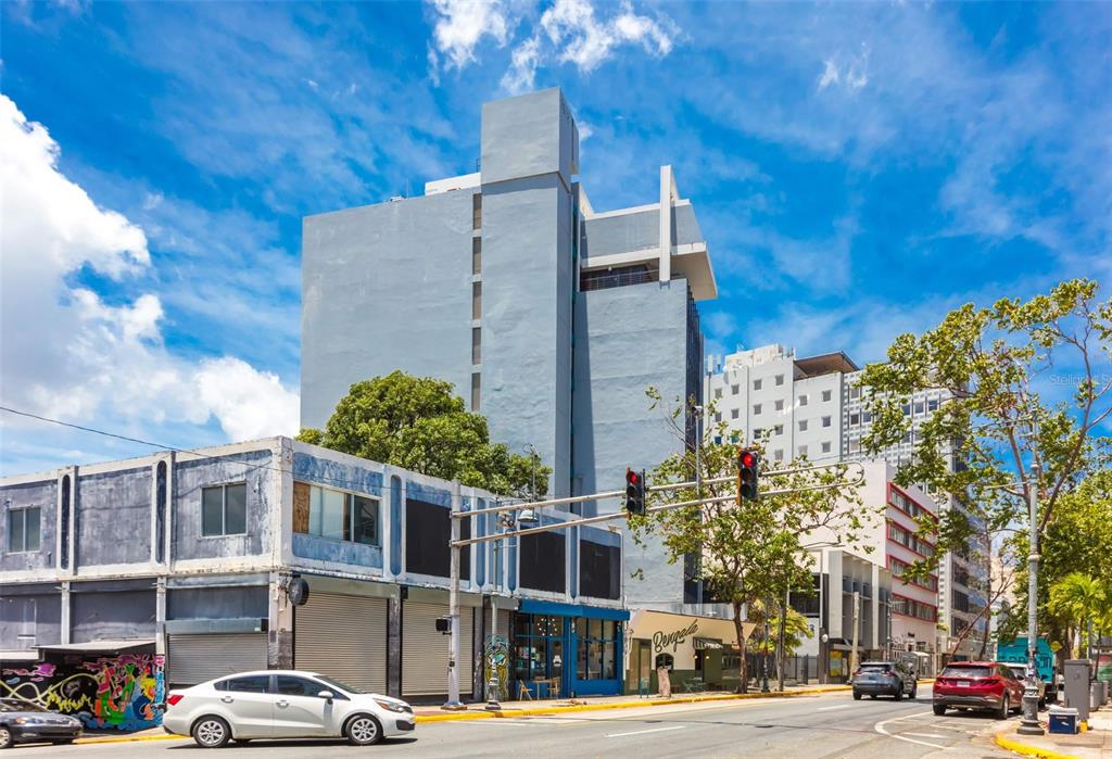 A multi-story blue building stands on a city street corner with a white car parked — 1612 PONCE DE LEON AVENUE, SAN JUAN, PR