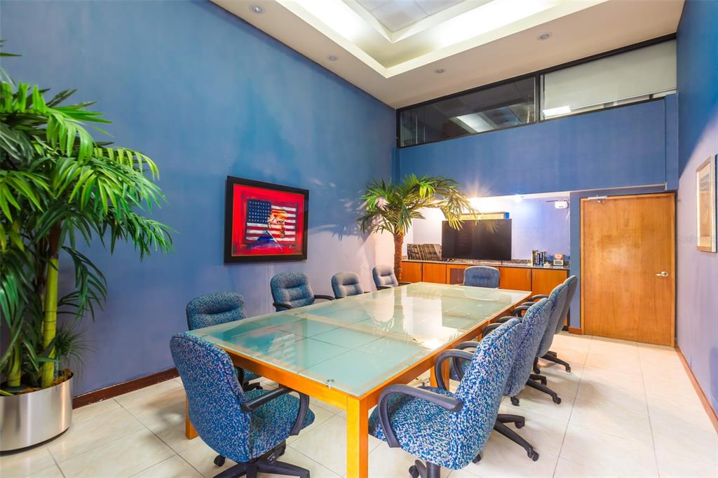 A conference room features a glass-topped table, blue patterned chairs, and a blue accent wall — 1612 PONCE DE LEON AVENUE, SAN JUAN, PR