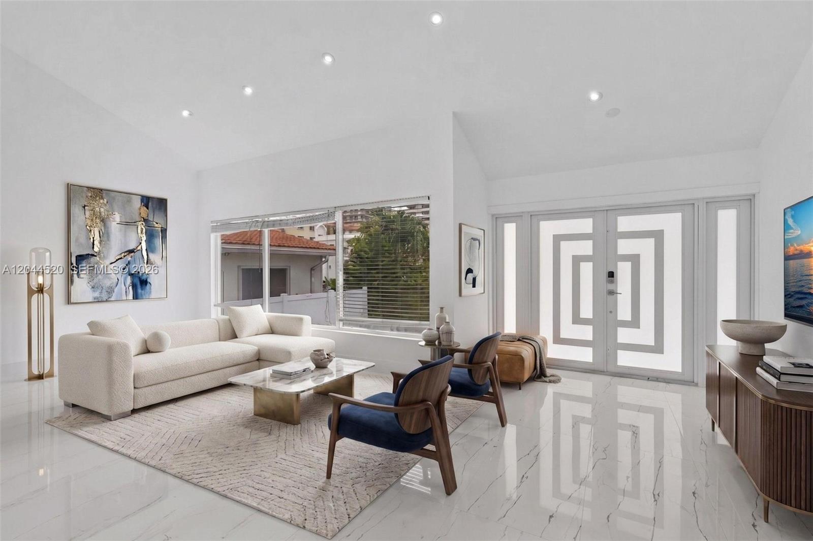 A bright living room features white marble floors, a cream sectional, and blue accent chairs — 8858 Harding Ave, Surfside FL 33154, SURFSIDE, FL