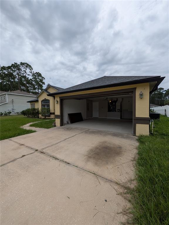 An exterior view of a house featuring an open two-car garage and a concrete driveway — 43 RAEMOOR DRIVE, PALM COAST, FL