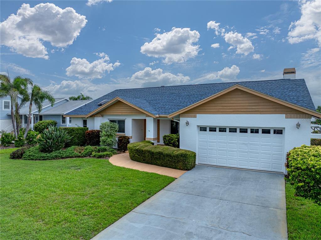 A single-story house with a white stucco exterior, brown gables, and a two-car garage — 366 6TH AVENUE N, TIERRA VERDE, FL