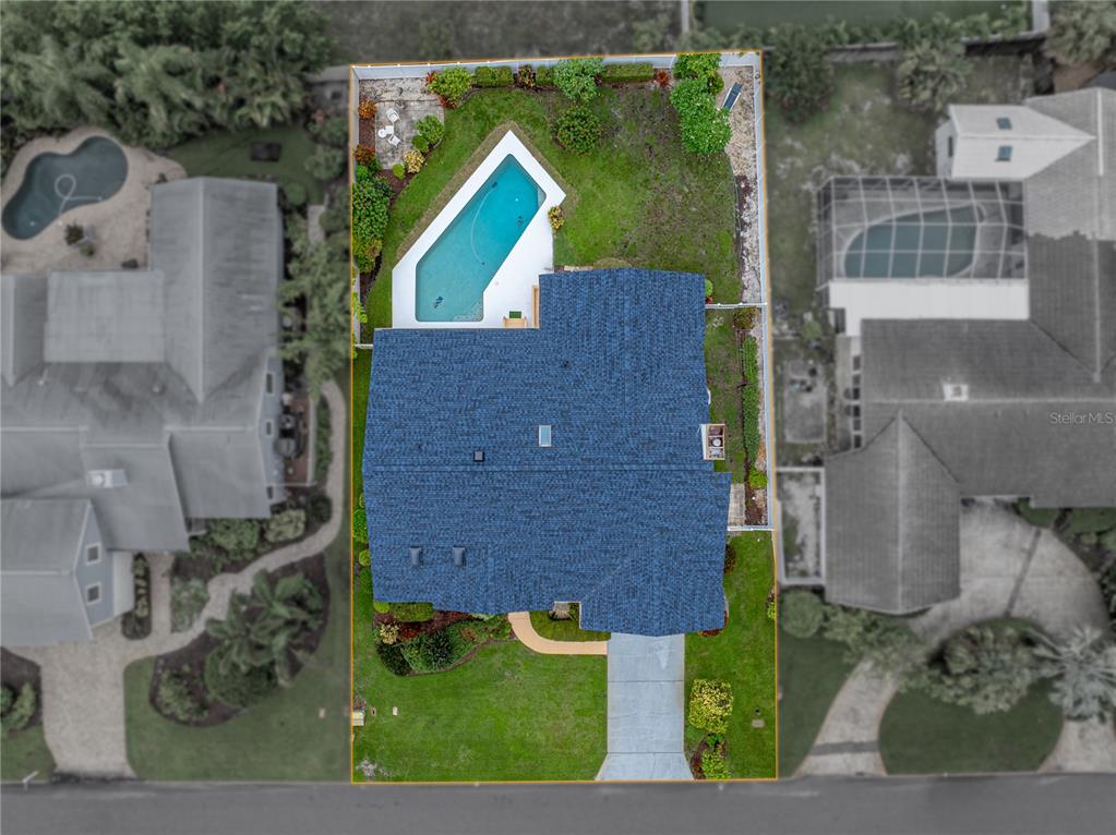 Aerial view of a residential property featuring a house, swimming pool, and landscaped yard — 366 6TH AVENUE N, TIERRA VERDE, FL