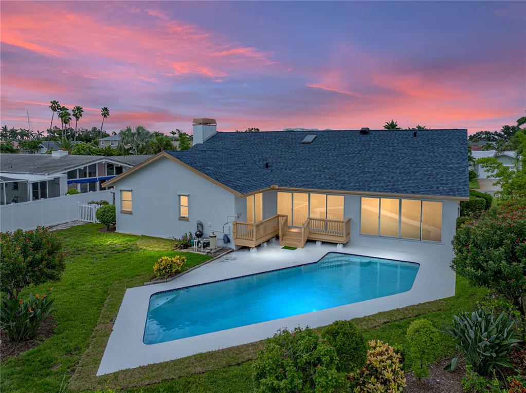 An aerial view of a house exterior with a swimming pool and a wooden deck — 366 6TH AVENUE N, TIERRA VERDE, FL