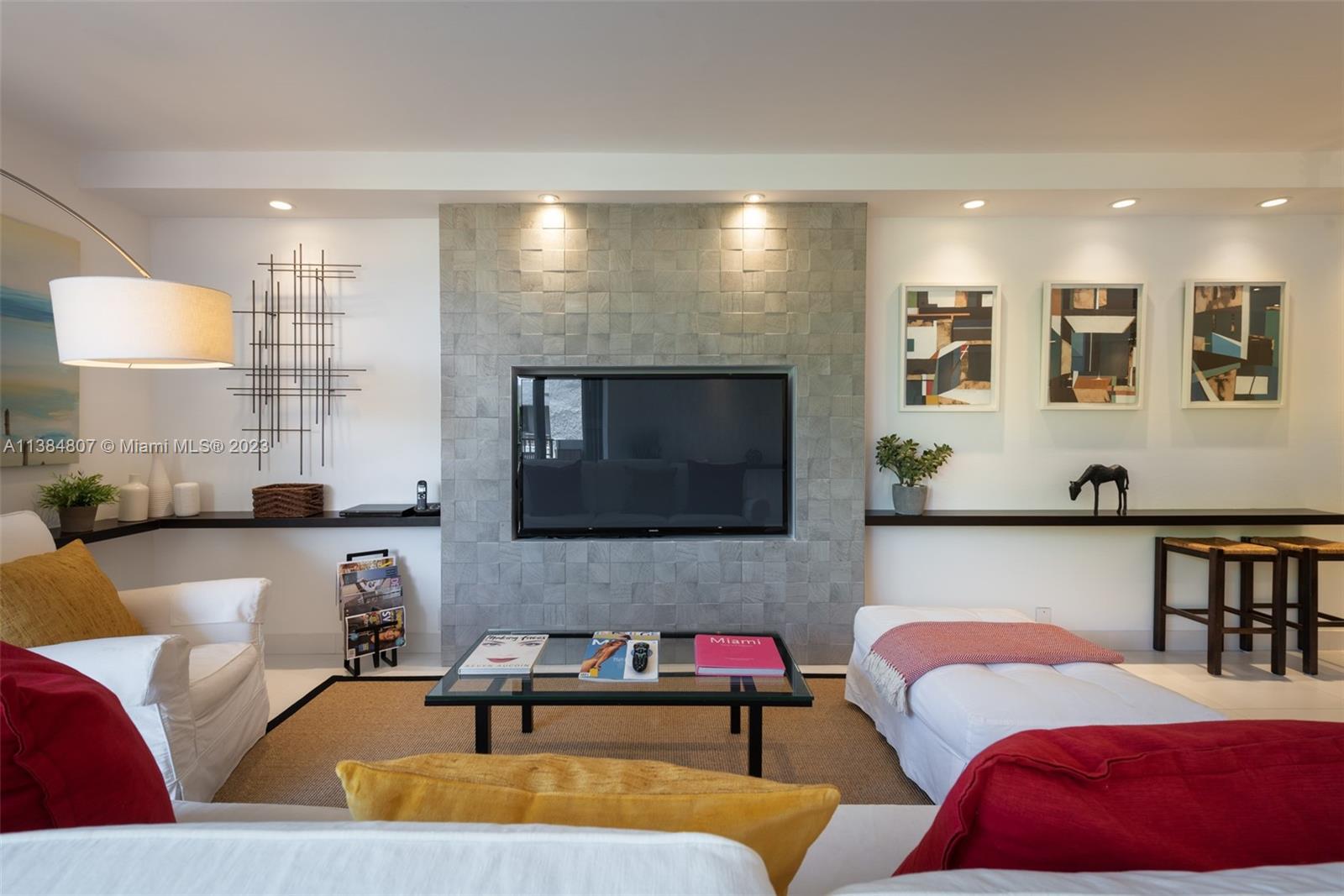 A living room features a central gray tiled fireplace wall with a built-in television — 121 Crandon Blvd # 463, Key Biscayne FL 33149, KEY BISCAYNE, FL