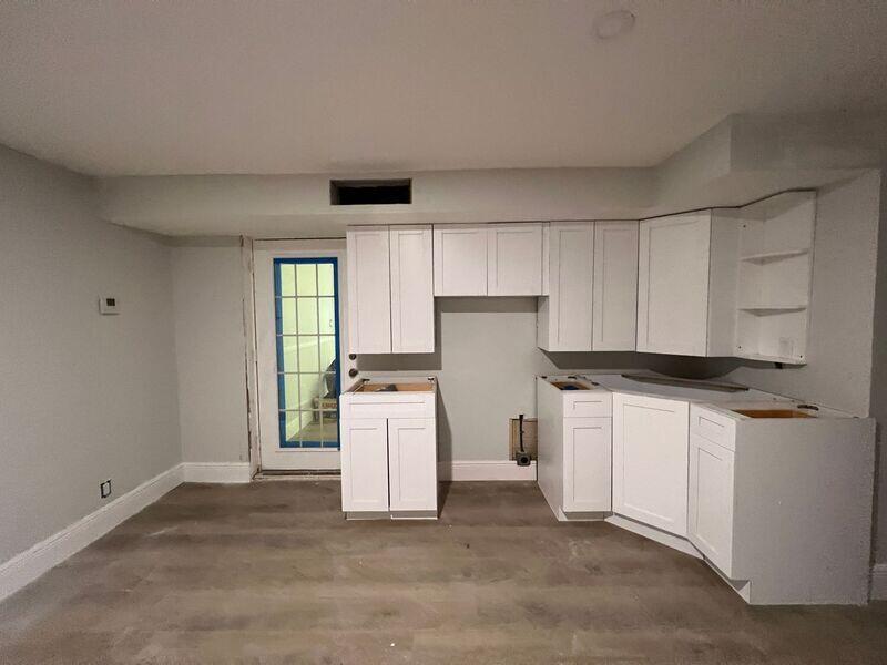 A kitchen under renovation features white cabinets, light gray walls, and wood-look flooring — 6511 Seminole Drive # 2, Atlantis FL 33462, ATLANTIS, FL