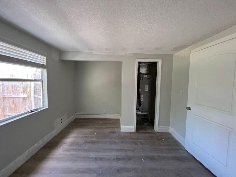 An interior room features light gray walls, wood-look flooring, a window, and a utility closet — 6511 Seminole Drive # 2, Atlantis FL 33462, ATLANTIS, FL