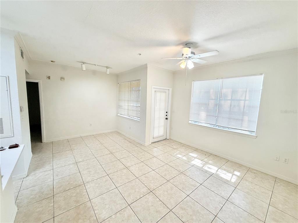 An empty room with white walls, tile flooring, a ceiling fan, and large windows — 2674 ROBERT TRENT JONES DRIVE UNIT 312, ORLANDO, FL