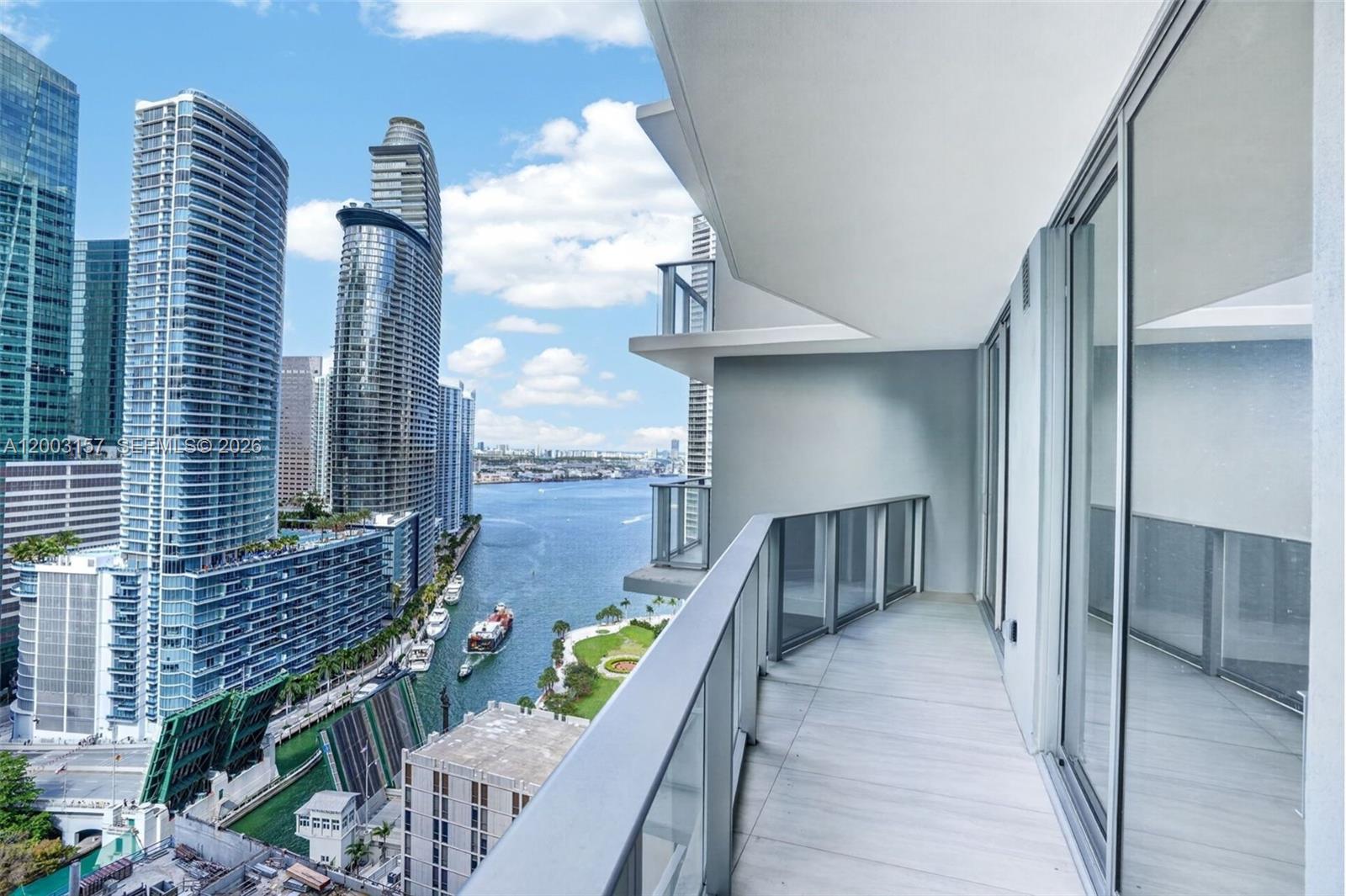 A high-rise balcony overlooks a city skyline, a river, and a drawbridge — 77 SE 5th St # 2705, Miami FL 33131, MIAMI, FL