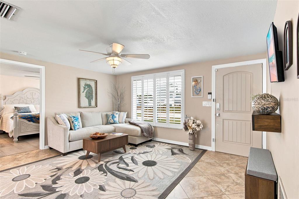 A single-story house with a white exterior, blue shutters, and a landscaped front lawn at dusk — 415 BRIARWOOD ROAD, VENICE, FL