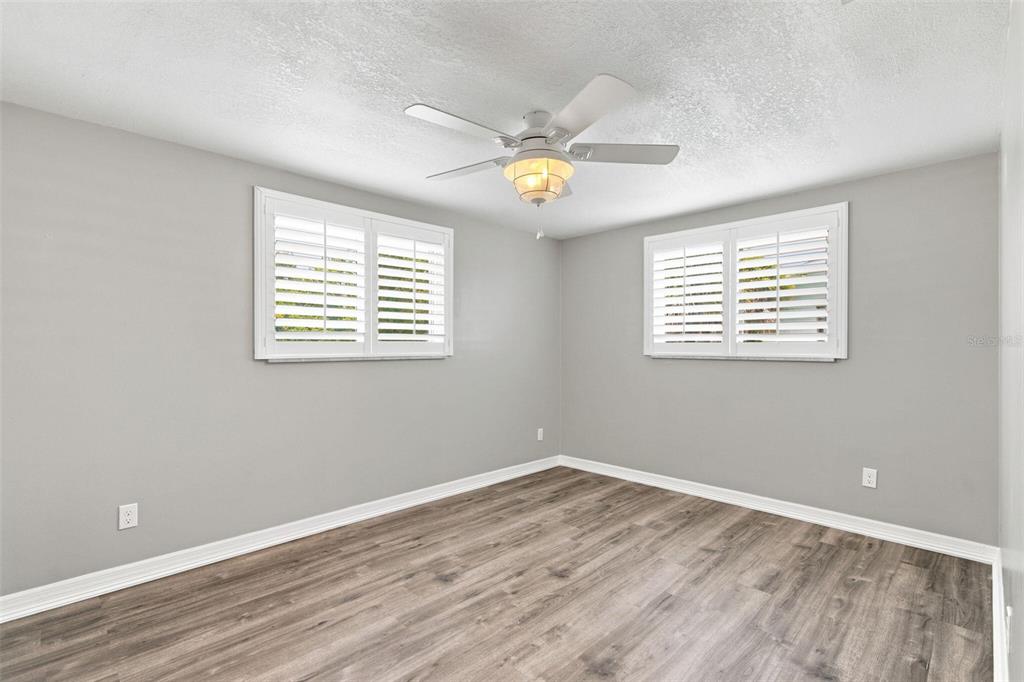 A living room features a sectional sofa, a floral rug, and a ceiling fan — 415 BRIARWOOD ROAD, VENICE, FL
