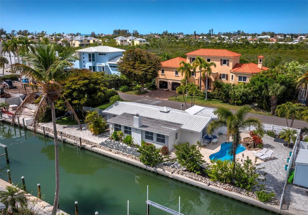 An aerial view of a waterfront house with a pool, patio, and boat dock — 726 JUNGLE QUEEN WAY, LONGBOAT KEY, FL