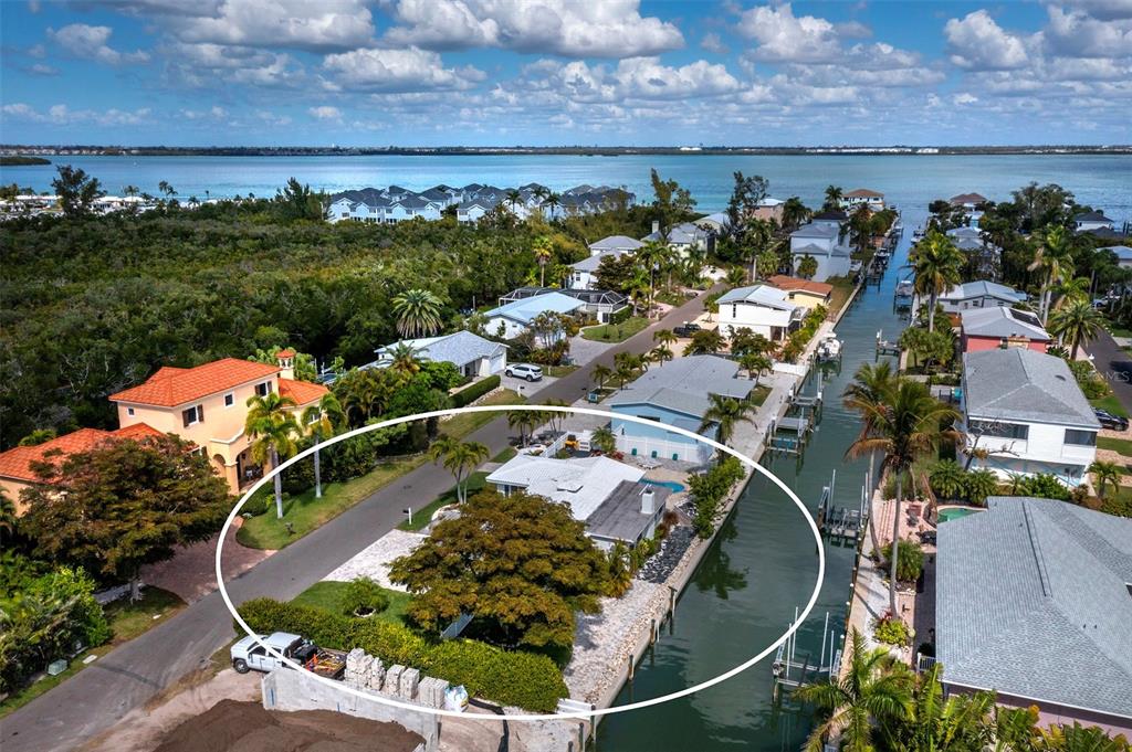 An aerial view of a waterfront house with a large tree and a private dock — 726 JUNGLE QUEEN WAY, LONGBOAT KEY, FL