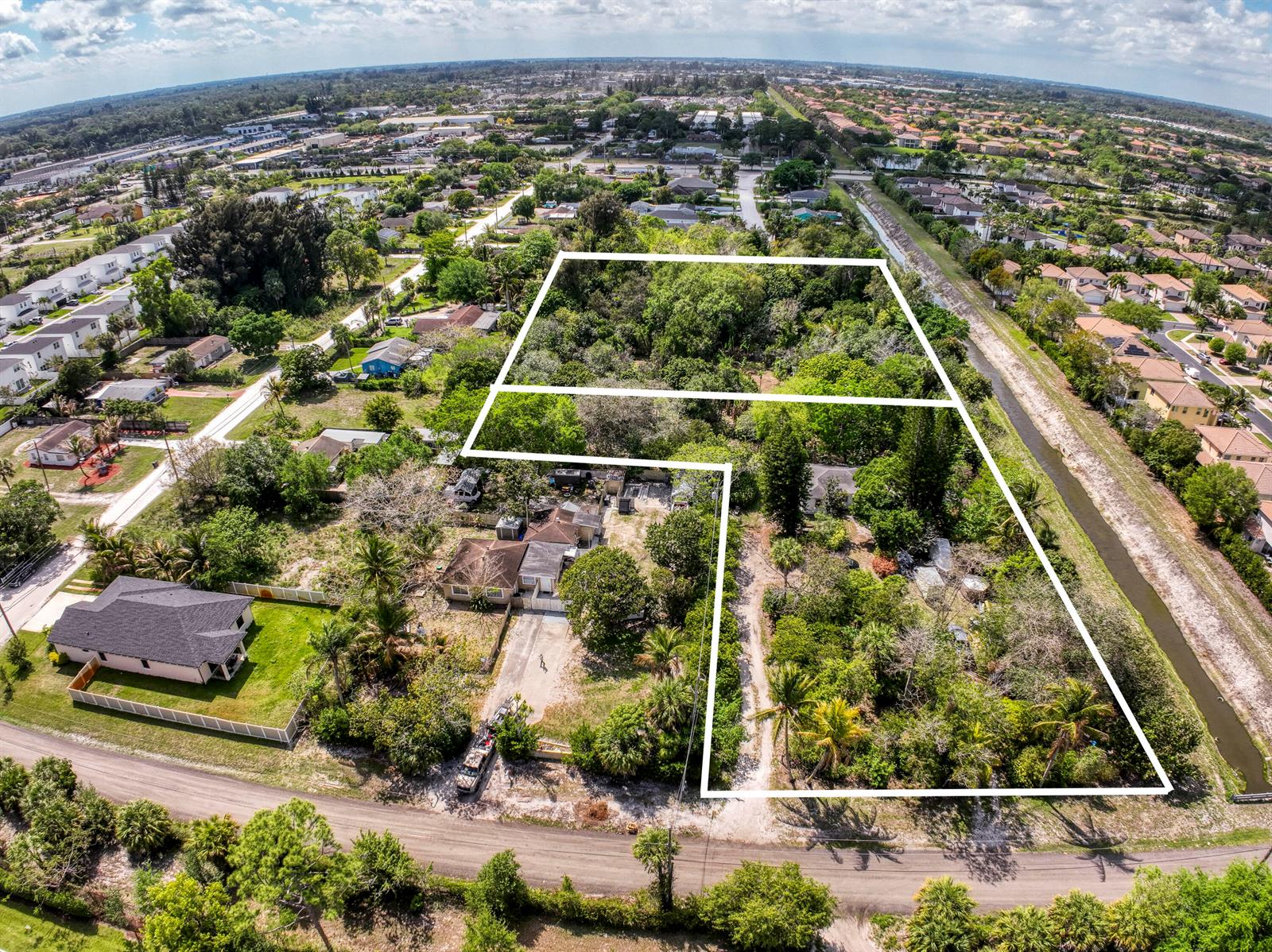 An aerial view shows a large, wooded residential lot outlined in white near a canal — 470 63rd Trail N, West Palm Beach FL 33413, WEST PALM BEACH, FL