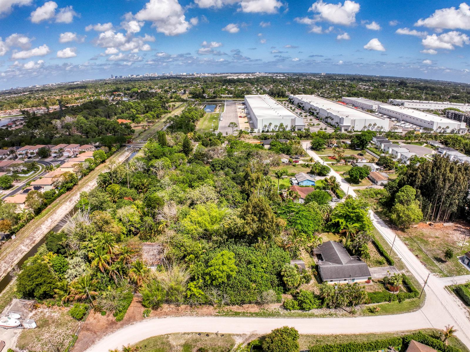 An aerial view shows a wooded lot with a house next to industrial warehouses — 470 63rd Trail N, West Palm Beach FL 33413, WEST PALM BEACH, FL