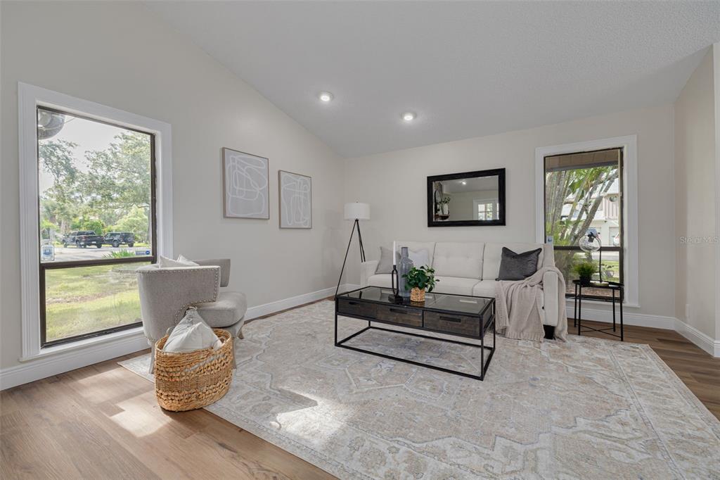 A living room features a white sofa, a coffee table, and a large area rug — 4415 MARINE PARKWAY, NEW PORT RICHEY, FL