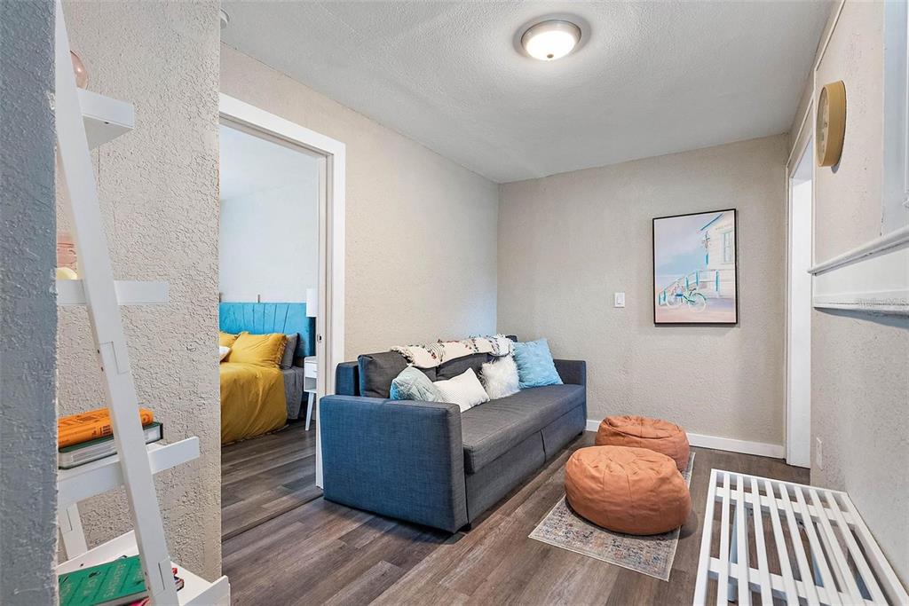 A living room features a gray sofa, two beanbag chairs, and a view into a bedroom — 623 MOUND PARK WAY S, ST PETERSBURG, FL
