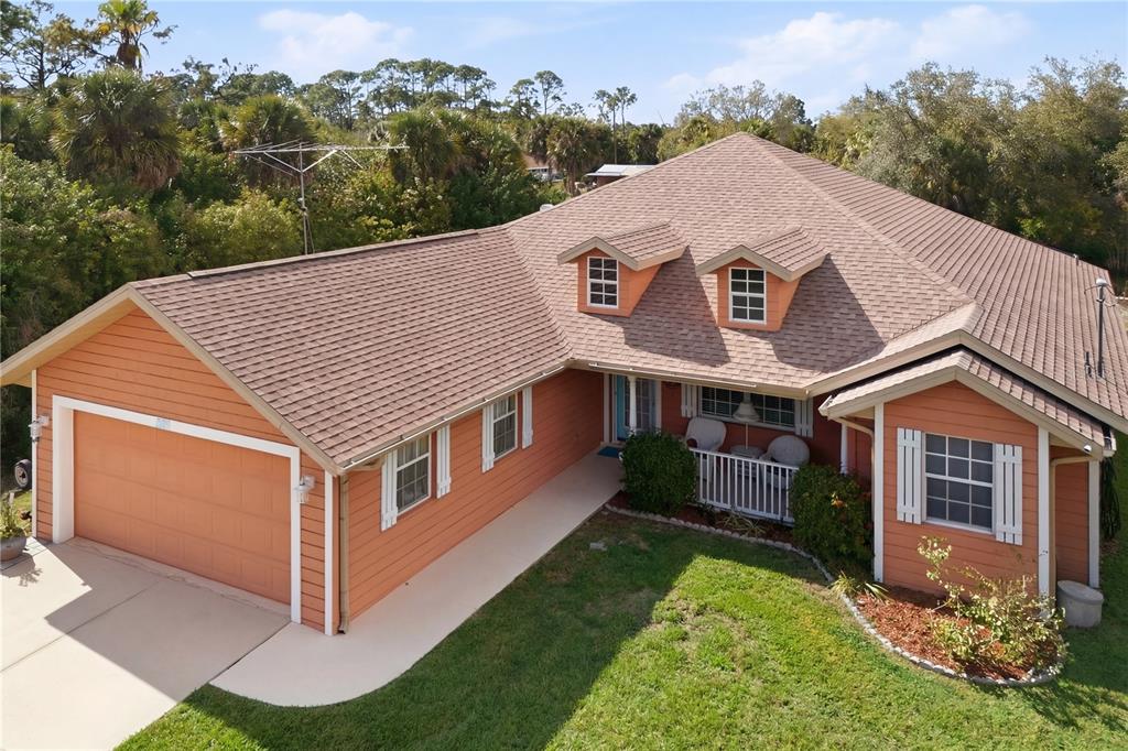 An aerial view of a single-story orange house with a brown shingled roof — 361 CHESHIRE STREET, PORT CHARLOTTE, FL