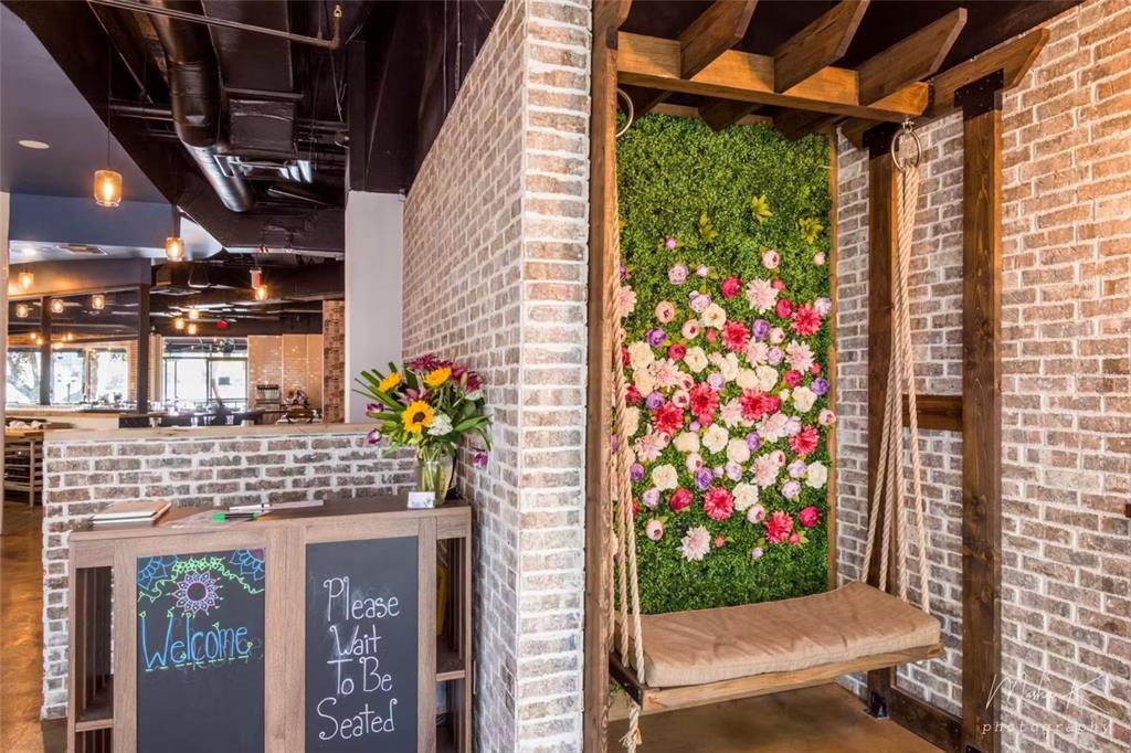 A restaurant entrance features a wooden host stand, brick walls, and a floral swing seat — 407 E CENTRAL BOULEVARD, ORLANDO, FL