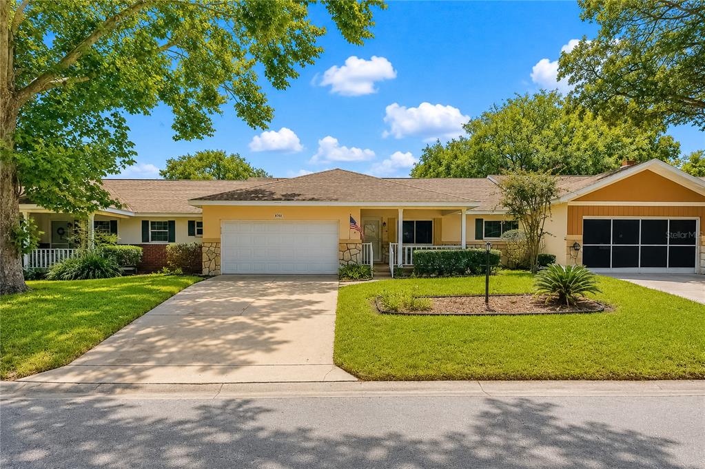 A single-story house with a two-car garage, a concrete driveway, and a front porch — 8702 SW 94TH STREET UNIT E, OCALA, FL