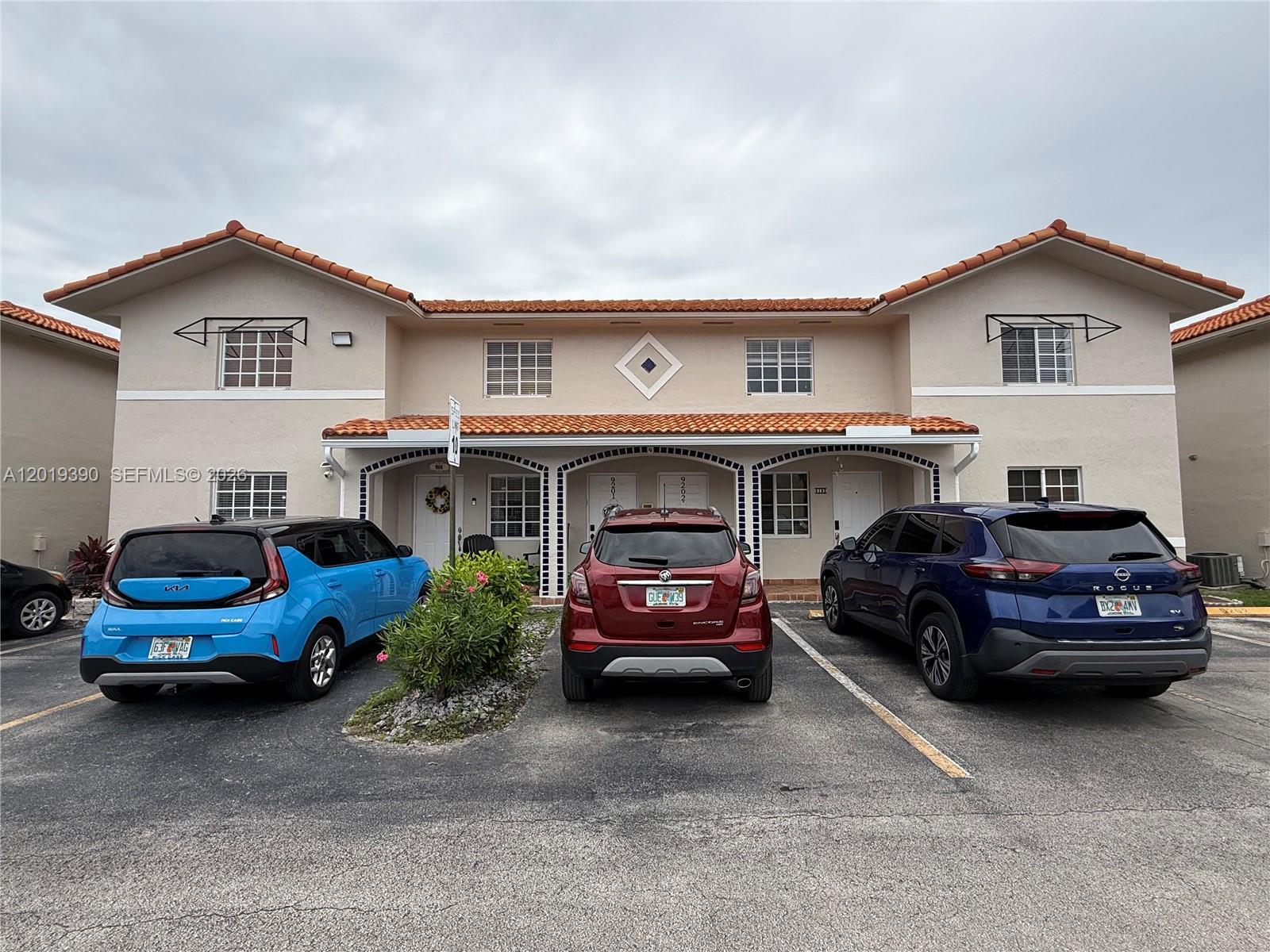 A two-story residential building with a tiled roof and three parked cars in front — 10101 W Okeechobee Rd # 9202, Hialeah Gardens FL 33016, HIALEAH GARDENS, FL