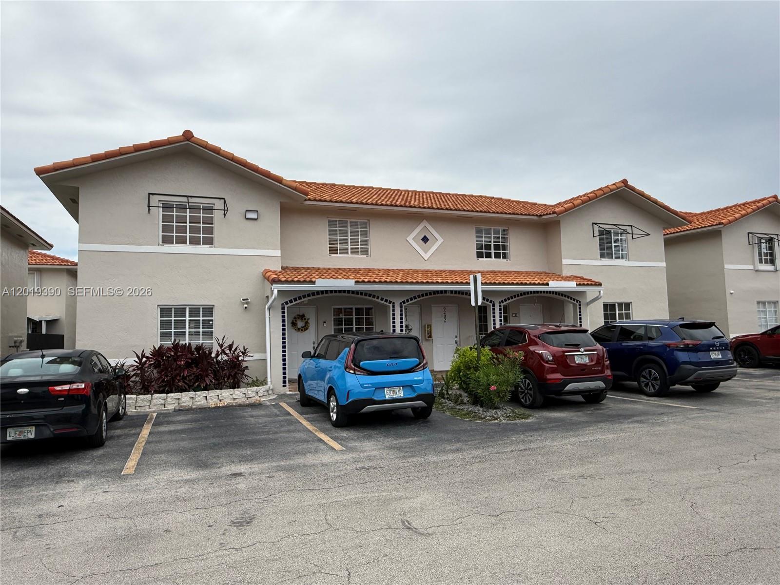 A two-story residential building with a terracotta tile roof and multiple parked cars — 10101 W Okeechobee Rd # 9202, Hialeah Gardens FL 33016, HIALEAH GARDENS, FL