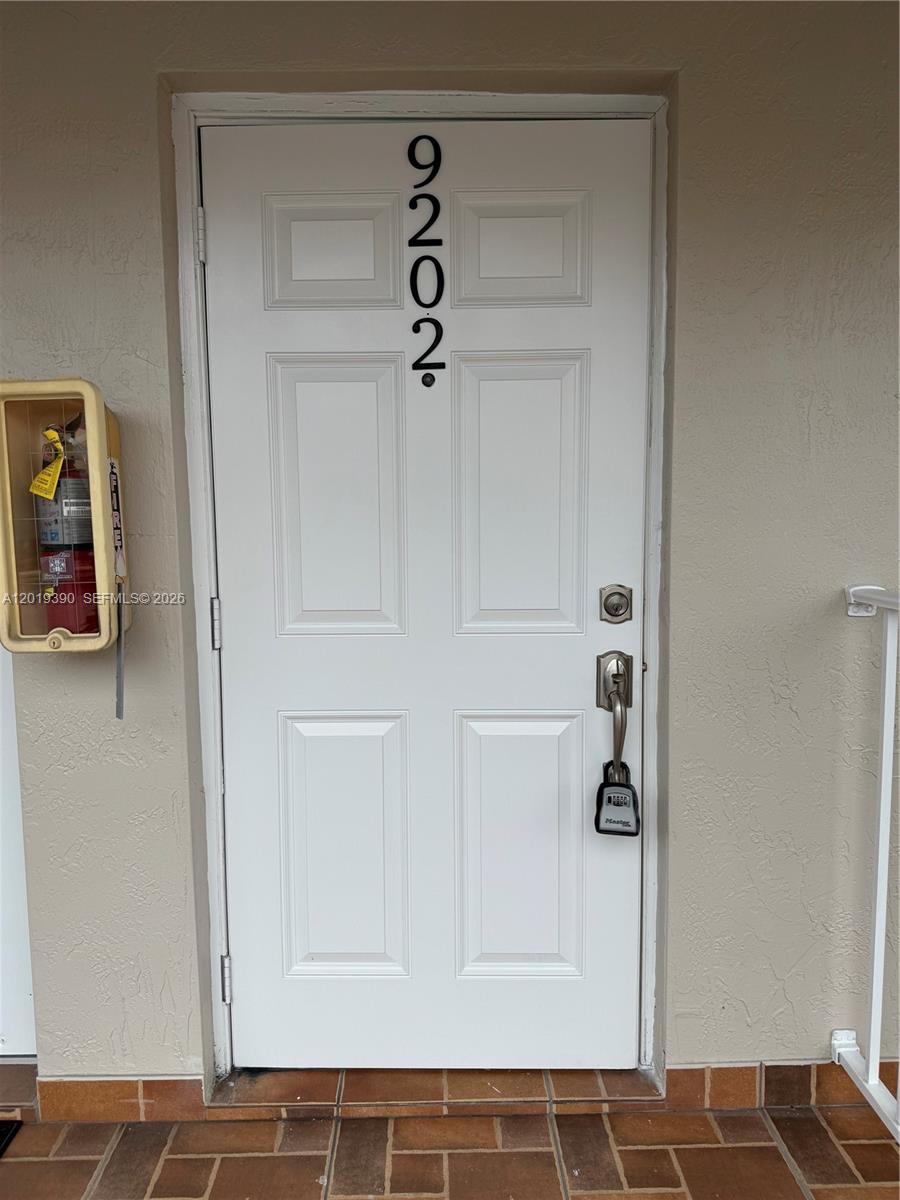 A white front door with the number 9202 and a lockbox attached to the handle — 10101 W Okeechobee Rd # 9202, Hialeah Gardens FL 33016, HIALEAH GARDENS, FL