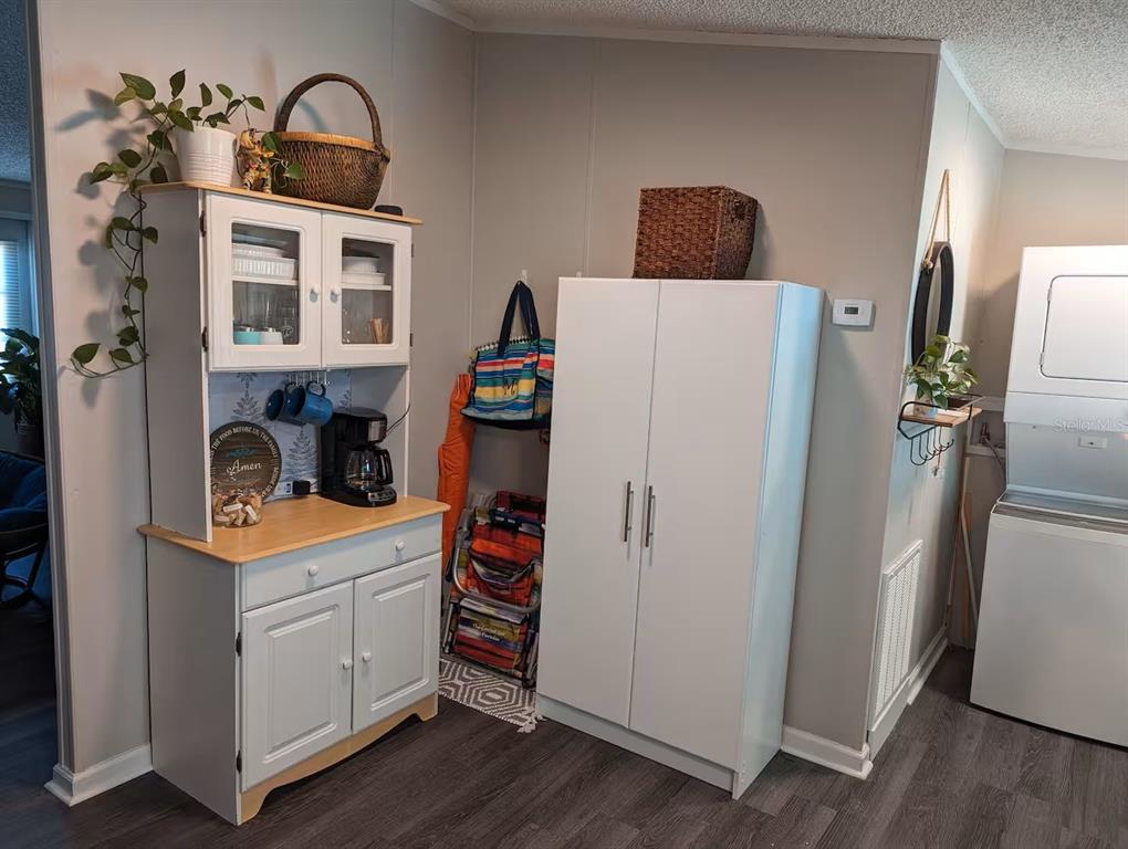 A kitchen area features a white hutch, a tall storage cabinet, and a stacked laundry unit — 12970 SPENCER STREET, FORT MYERS, FL