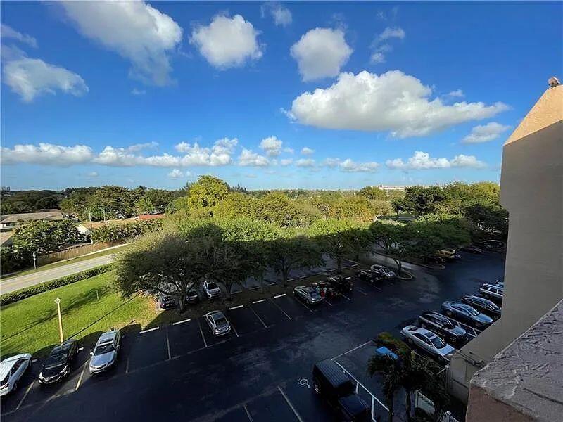 An elevated view shows a parking lot surrounded by trees under a blue sky — 3001 W Rolling Hills # 608, Davie FL 33328, DAVIE, FL