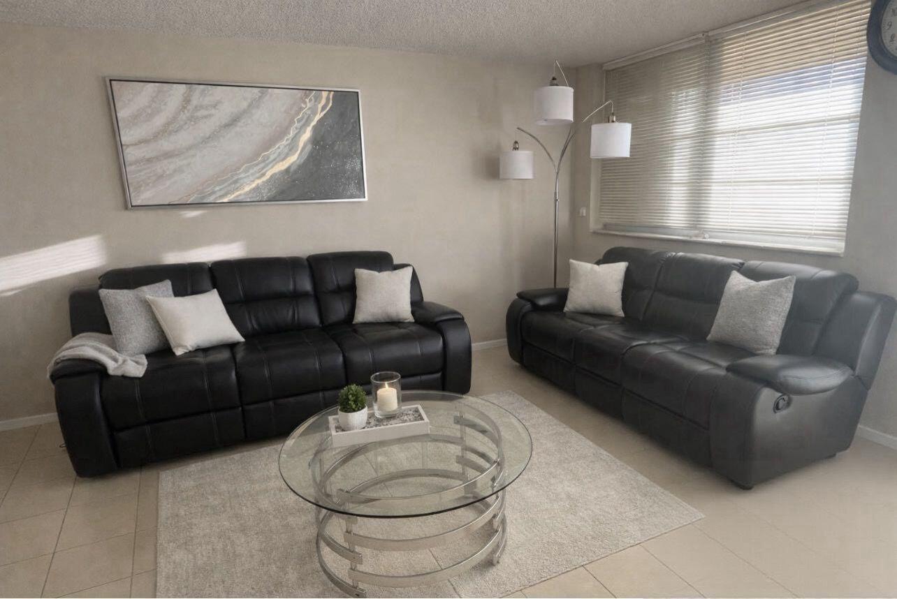 A living room features two black leather sofas, a glass coffee table, and wall art — 3001 W Rolling Hills # 608, Davie FL 33328, DAVIE, FL