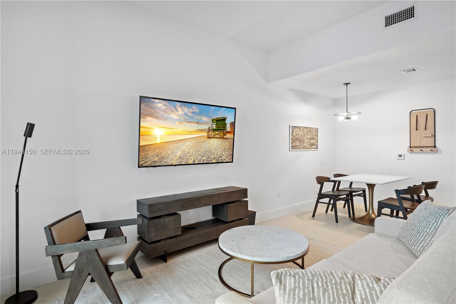 A modern living and dining area features a wall-mounted television, wooden console, and marble table — 159 NE 6th St # 5113, Miami FL 33132, MIAMI, FL