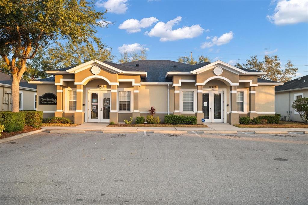 A single-story commercial building with two entrance doors and a paved parking lot in front — 17929 HUNTING BOW CIRCLE UNIT 101 & 102, LUTZ, FL