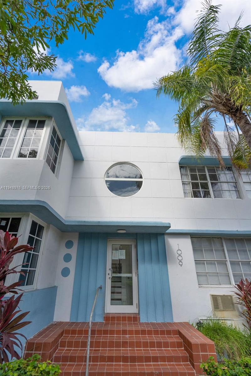 A two-story Art Deco building features a central circular window, blue accents, and brick steps — 1009 Meridian Ave # 15, Miami Beach FL 33139, MIAMI BEACH, FL