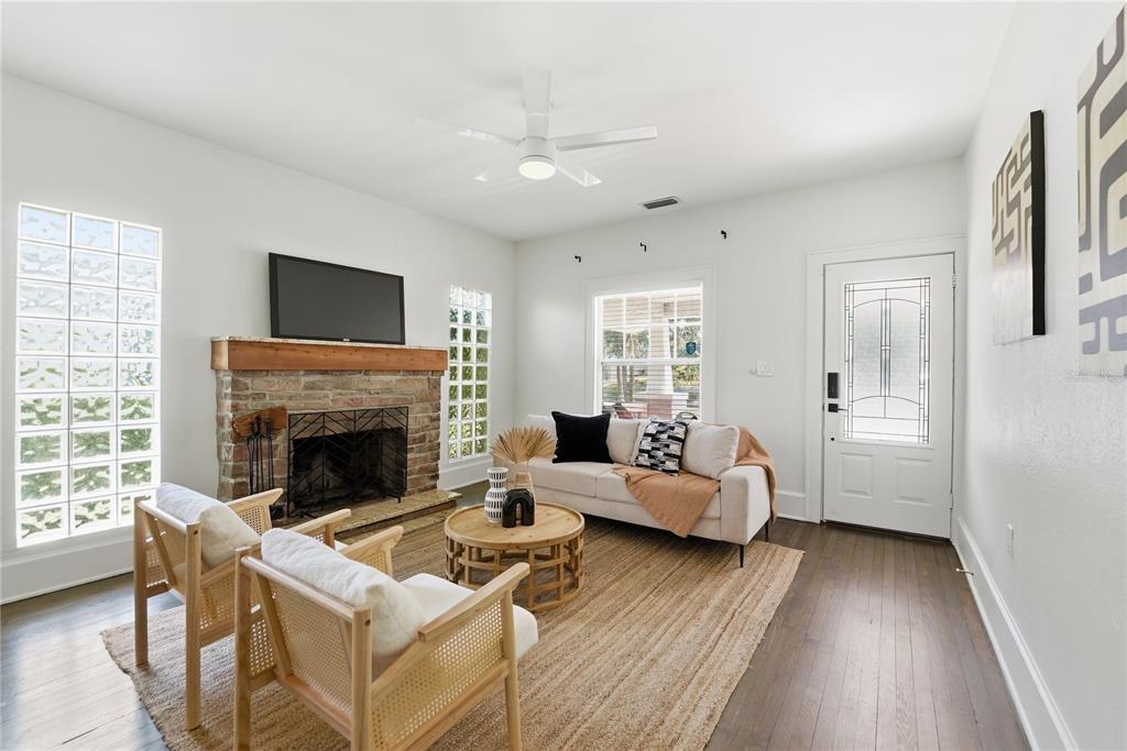 A living room features a brick fireplace, glass block windows, a sofa, and two chairs — 204 N BROWN AVENUE, ORLANDO, FL