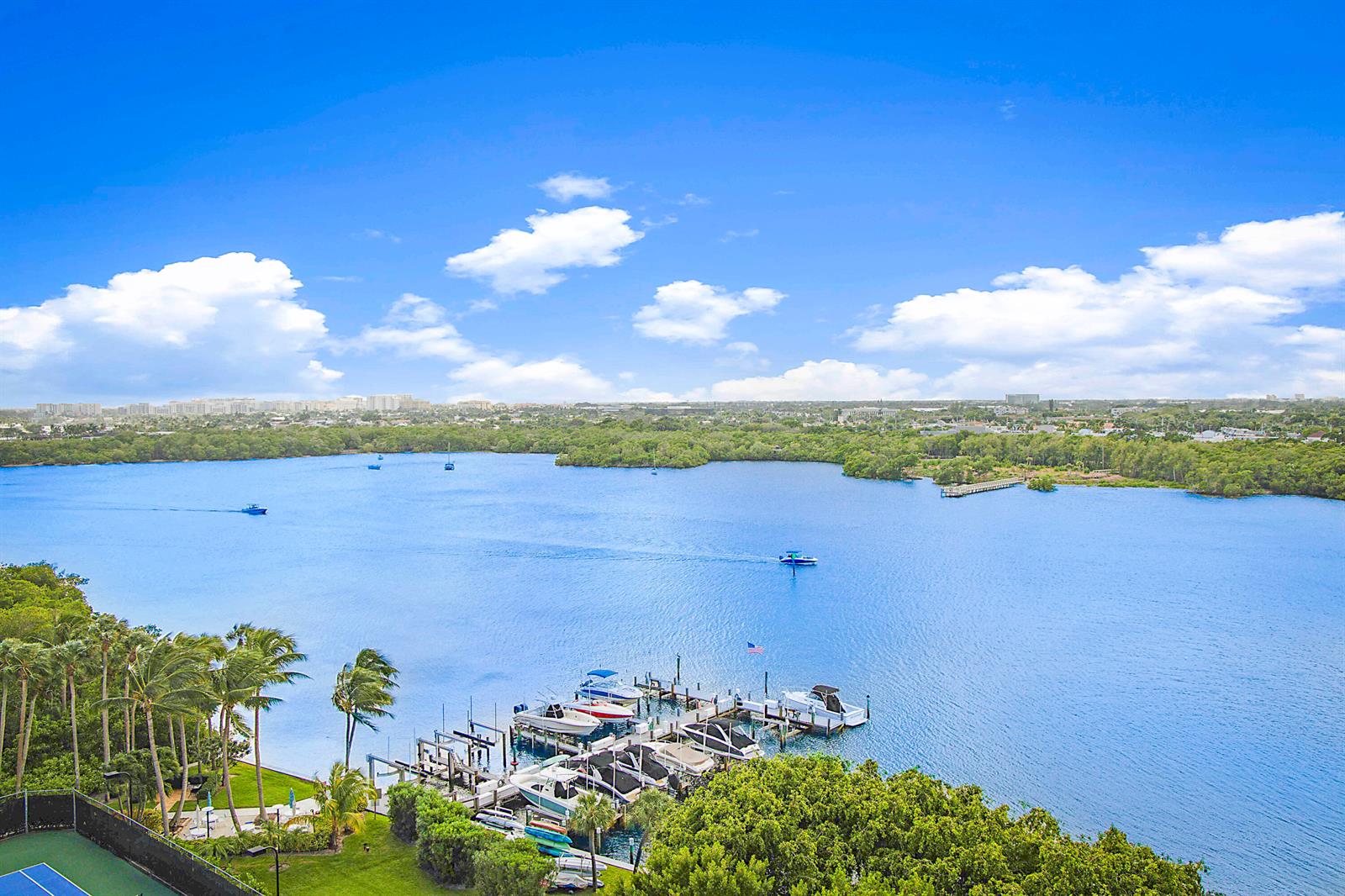 An aerial view shows a marina with several boats docked along a lush shoreline — 2121 N Ocean Boulevard # 1507w, Boca Raton FL 33431, BOCA RATON, FL