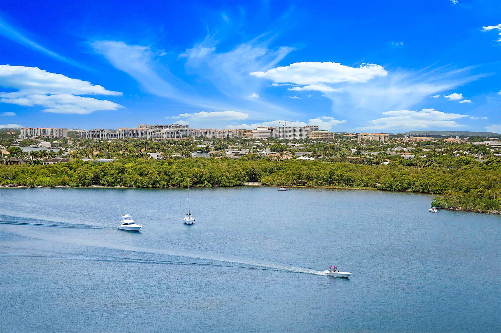 An aerial view of a bay with several boats and a coastal city in the background — 2121 N Ocean Boulevard # 1507w, Boca Raton FL 33431, BOCA RATON, FL