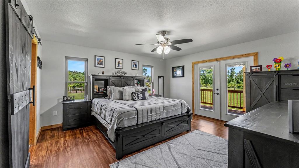 A bedroom features a dark wood bed frame, sliding barn door, and glass patio doors — 339 MINI RANCH ROAD, SEBRING, FL