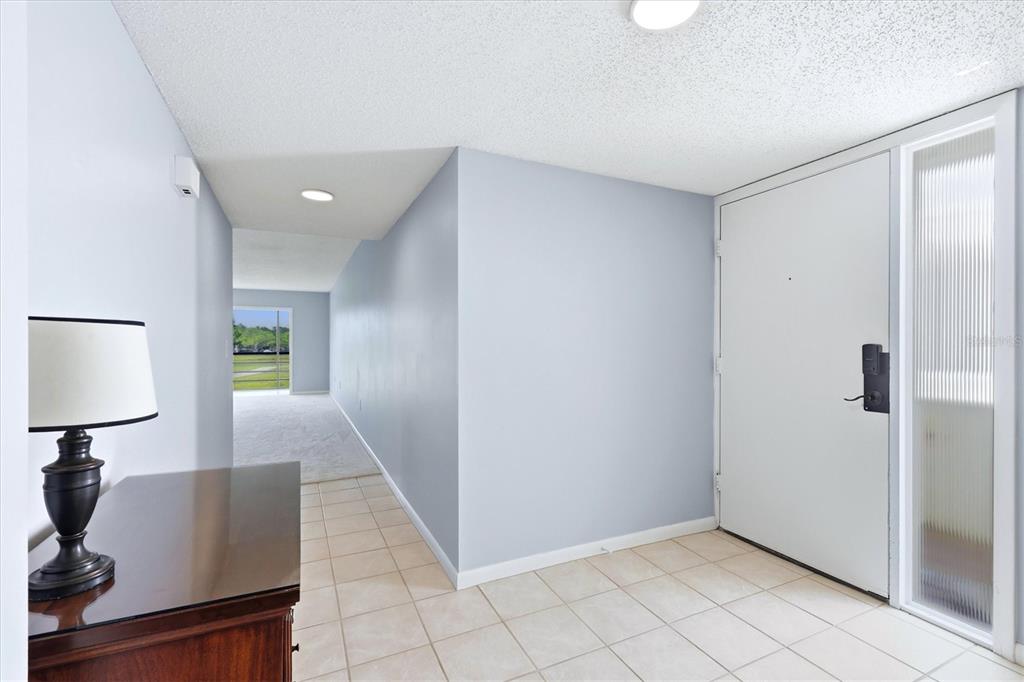 An entryway with light blue walls, tile flooring, and a white door with a side window — 5194 MARSH FIELD LANE UNIT 96, SARASOTA, FL